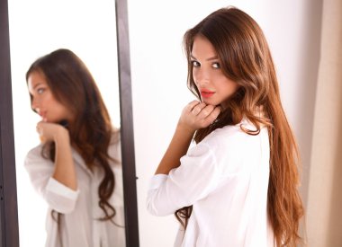 Genç kadın kendini evde aynada yansıma arıyor