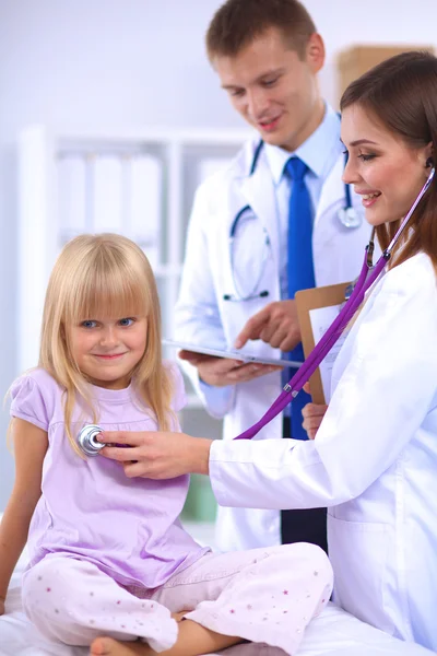 Médico femenino examinando a un niño con estetoscopio en cirugía —  Fotos de Stock