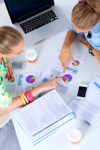 Dos mujeres trabajando juntas en la oficina, sentadas en el escritorio — Foto de Stock