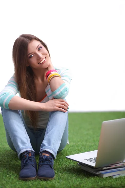 Jeune femme avec ordinateur portable assis sur l'herbe verte — Photo