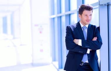 Ofisteki pencerenin yanında duran işadamının portresi