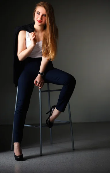 Junge Frau sitzt auf einem Stuhl — Stockfoto