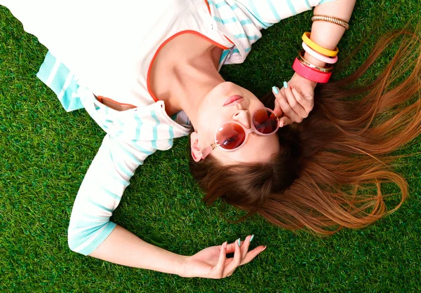 Mooie jonge vrouw liggend op groen gras — Stockfoto