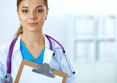 Kadın doktor hastanede dosyayla bekliyor.