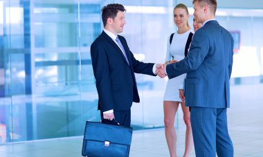 İki başarılı iş adamının el sıkışırken tam boy görüntüsü.