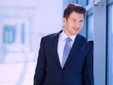 Ofisteki pencerenin yanında duran işadamının portresi