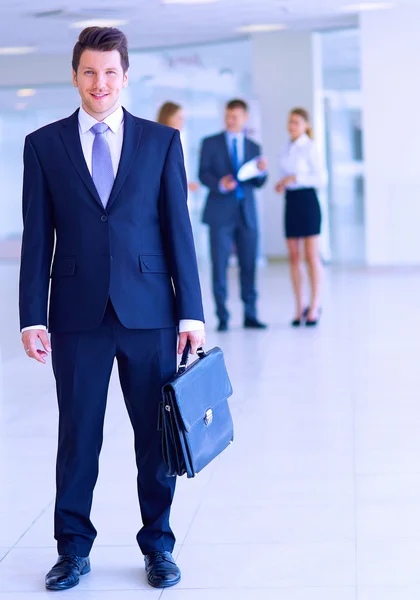 Retrato de un joven empresario en el cargo con colegas en segundo plano —  Fotos de Stock