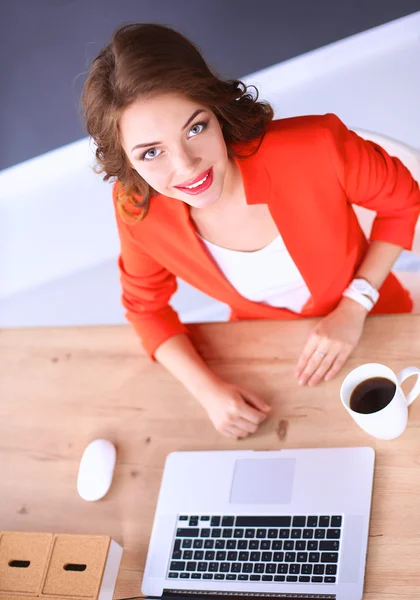 Atrakcyjna kobieta siedząca przy biurku w biurze, pracująca z laptopem — Zdjęcie stockowe