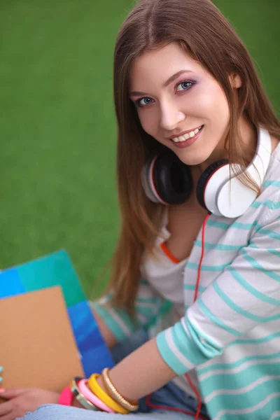 Mujer leyendo libro se sienta en la hierba verde — Foto de Stock