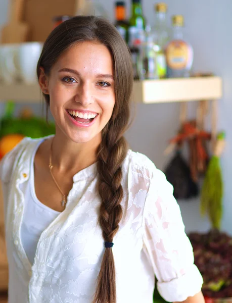 Junge Frau steht neben Schreibtisch in der Küche — Stockfoto