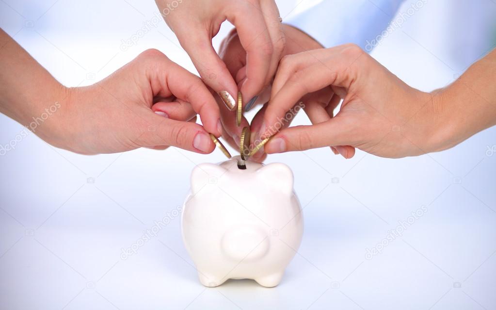 People putting coin into the piggy bank