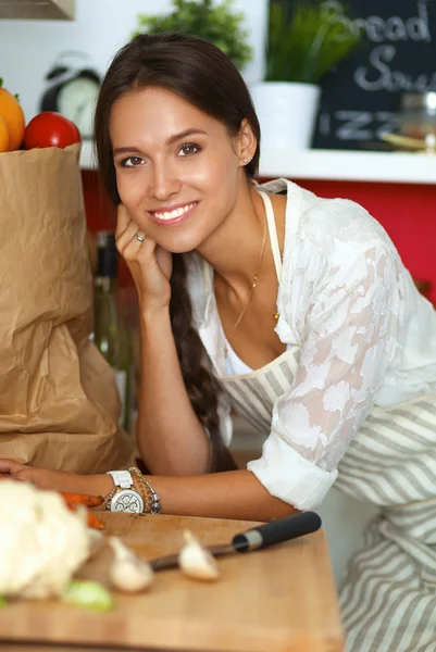 Young woman standing near desk in the kitchen — Stock Photo, Image