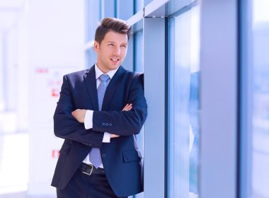 Ofisteki pencerenin yanında duran işadamının portresi