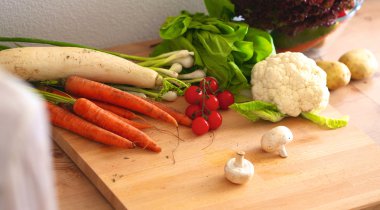 Mutfaktaki masanın üstünde sebzeler var.