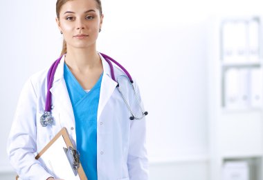 Kadın doktor hastanede dosyayla bekliyor.