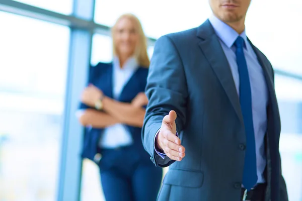 Joven hombre de negocios listo para apretón de manos de pie en la oficina —  Fotos de Stock