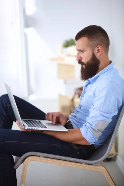 Jonge zakenman zit op stoel in functie — Stockfoto