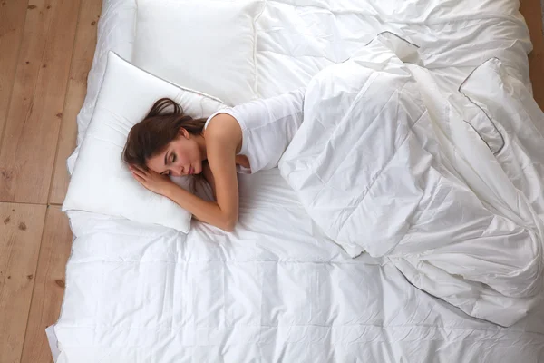 Güzel kız yatakta yatarken yatak odasında, uyuyor — Stok fotoğraf