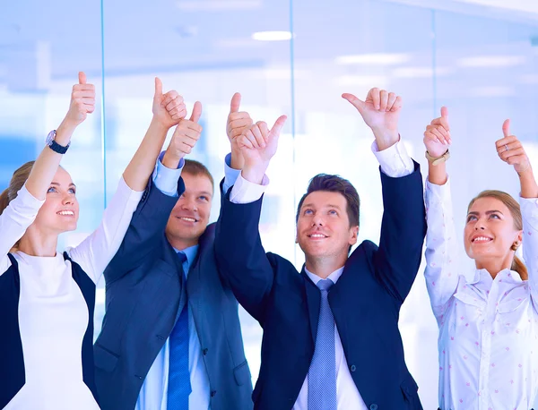 Happy business team showing thumbs up in office — Stock Photo, Image