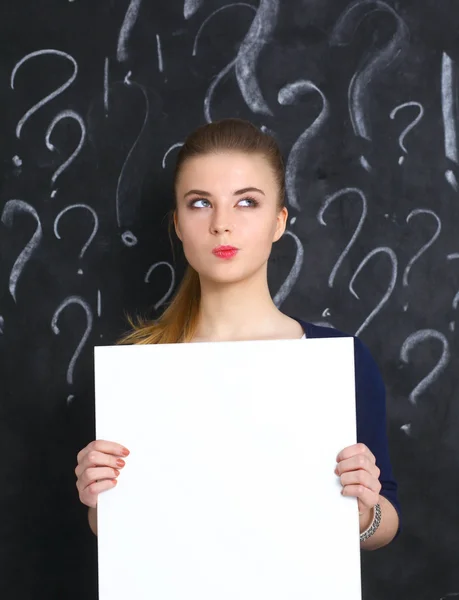 Young girl with question mark on a gray background — Stock Photo, Image