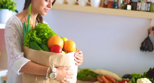 Young woman holding grocery shopping bag with vegetables — Stock Photo, Image