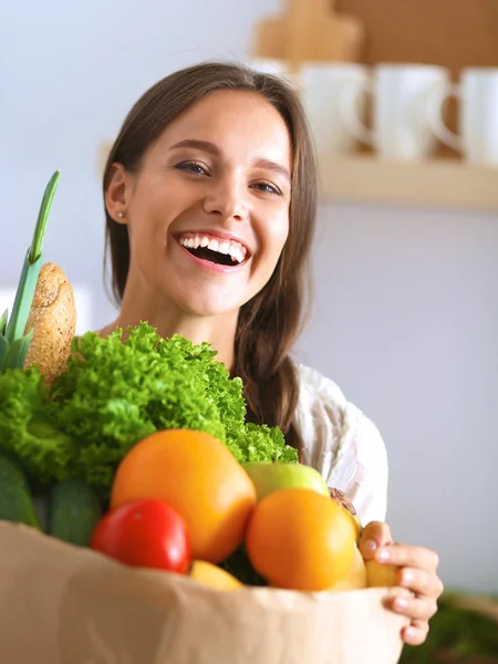 Mujer joven sosteniendo bolsa de la compra de comestibles con verduras — Foto de Stock
