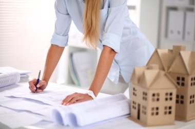 Ofisinde planları olan kadın mimarın portresi.