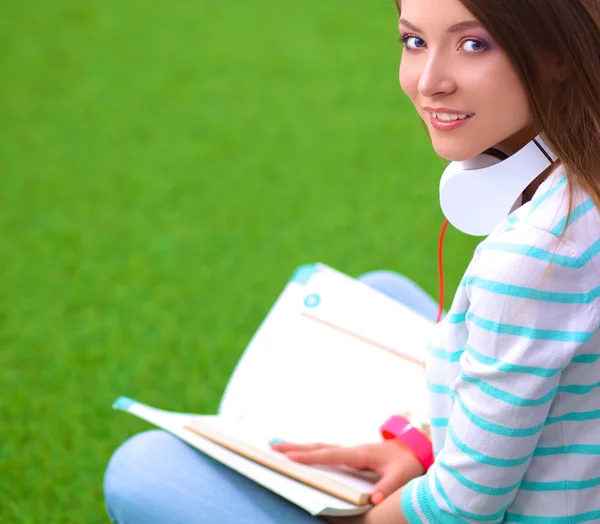 Femme livre de lecture se trouve sur l'herbe verte — Photo