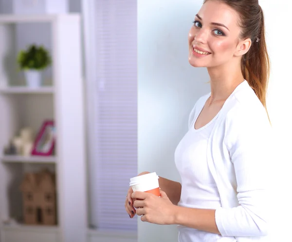 Attractive young businesswoman standing  near wall in office — Stock Photo, Image