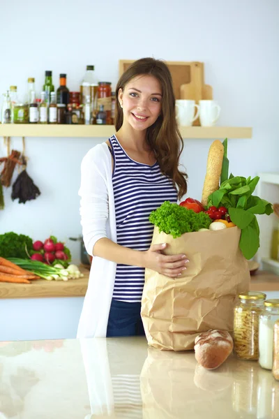 Молода жінка тримає продуктовий сумку з овочами — стокове фото