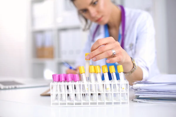Donna ricercatrice è circondata da fiale mediche e fiaschette, isolate su sfondo bianco — Foto Stock