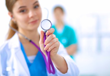 Steteskoplu kadın doktor dinliyor.