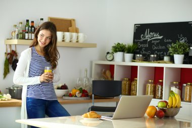 Gülümseyen kadın mutfakta tablet ve kredi kartı kullanarak alışveriş online