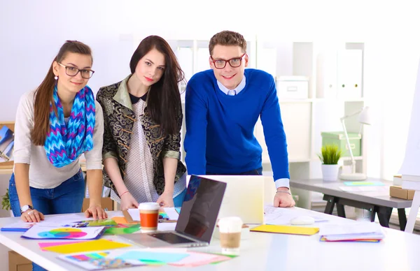 Young business people standing at office near desk — Stock Photo, Image