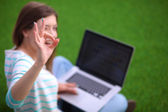 Fiatal nő laptop ül zöld fű