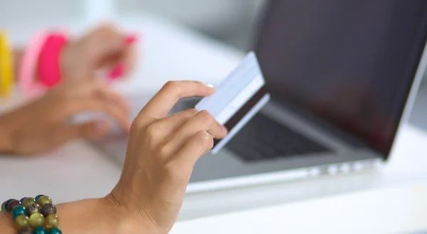 Duas jovens mulheres sentadas com laptop e carrinho de crédito em casa — Fotografia de Stock