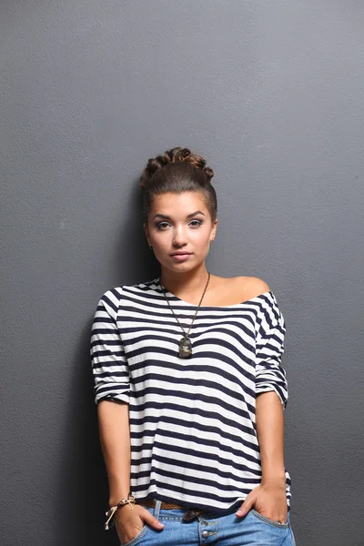 Young woman standing, isolated on gray background — Stock Photo, Image