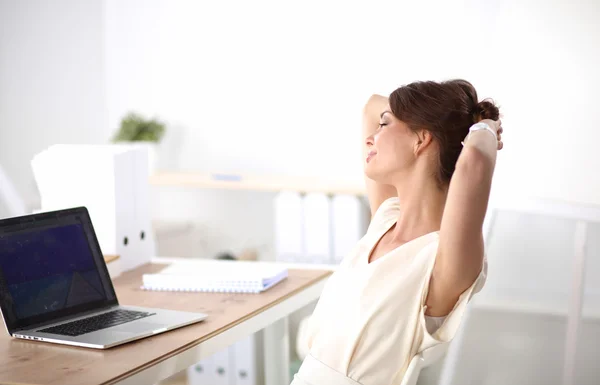 Zakelijke vrouw ontspannen met handen achter haar hoofd en zitten op een bureaustoel — Stockfoto