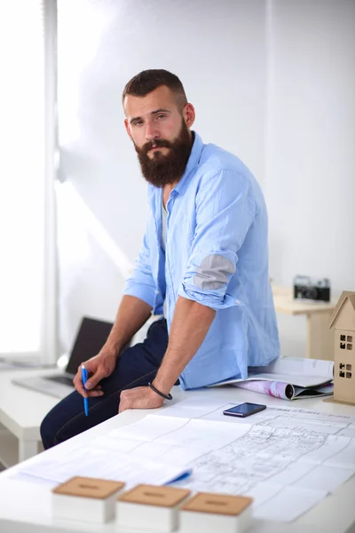 Retrato de diseñador masculino en sombrero con planos en el escritorio —  Fotos de Stock