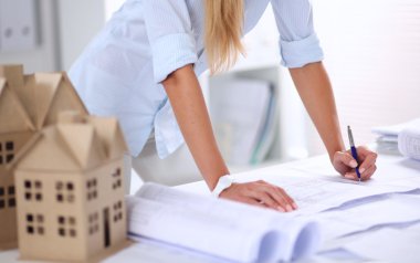 Ofisinde planları olan kadın mimarın portresi.