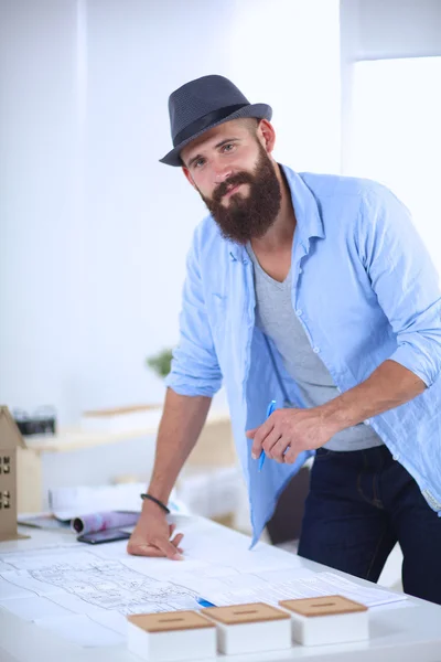 Portrait of male designer in hat with blueprints at desk — Stock Photo, Image