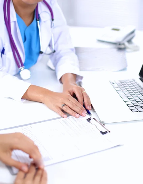 Female doctor sitting on the desk and working a laptop in hospital — Stock Photo, Image