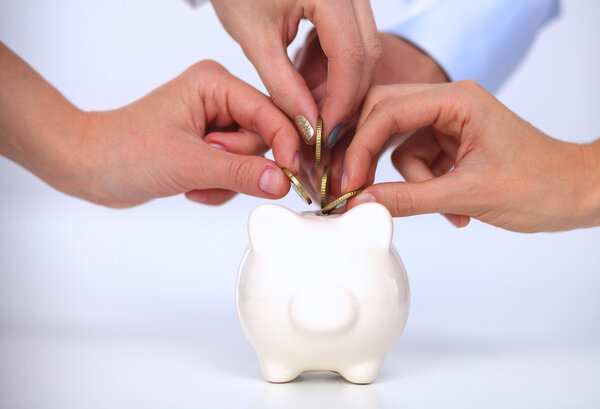 Люди кладут монеты в копилку
