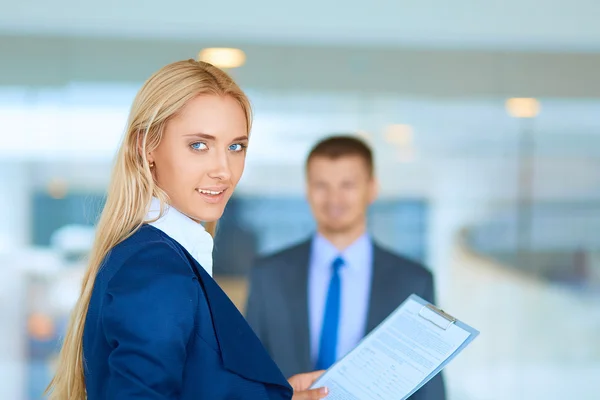 Zakenvrouw permanent in office, documenten in de hand houden — Stockfoto