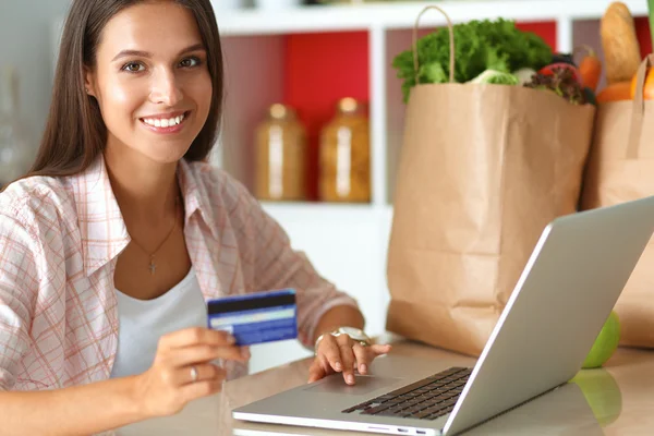 Donna sorridente shopping online con tablet e carta di credito in cucina — Foto Stock