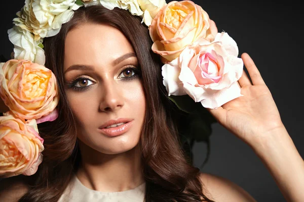 Retrato de uma mulher bonita com flores no cabelo. Moda — Fotografia de Stock