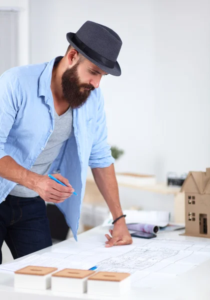 Retrato de diseñador masculino en sombrero con planos en el escritorio —  Fotos de Stock