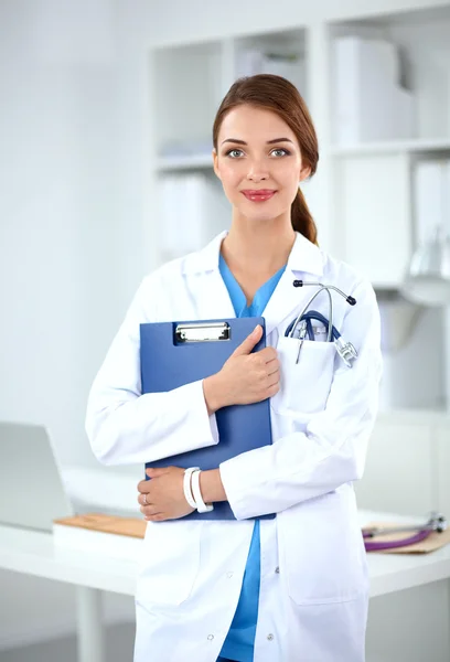 Retrato de una joven doctora con una bata blanca de pie en el hospital — Foto de Stock