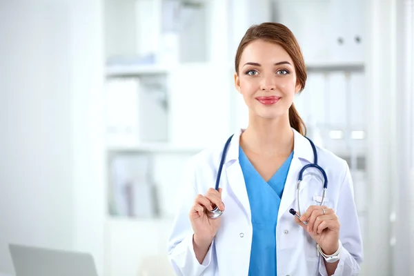 Portrait of young woman doctor with white coat standing in hospital — Stock Photo, Image