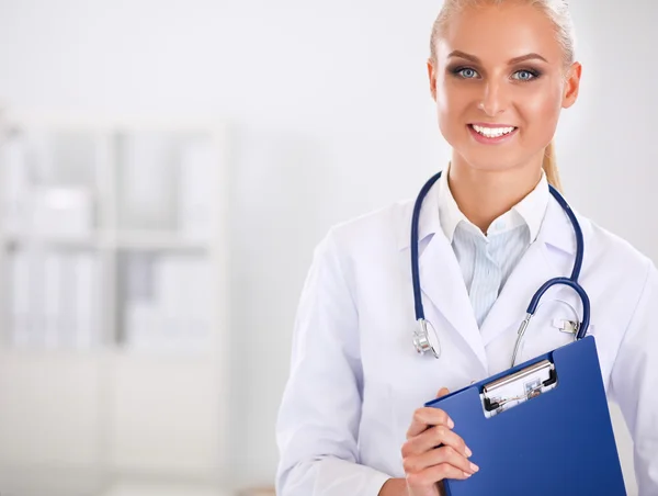 Médecin souriante avec un dossier en uniforme debout à l'hôpital — Photo